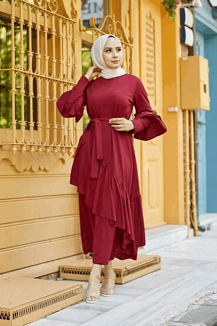 a woman wearing a red dress and a white hijab