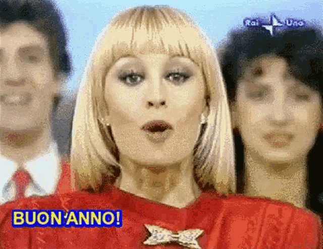 a woman in a red dress is standing in front of a group of people .