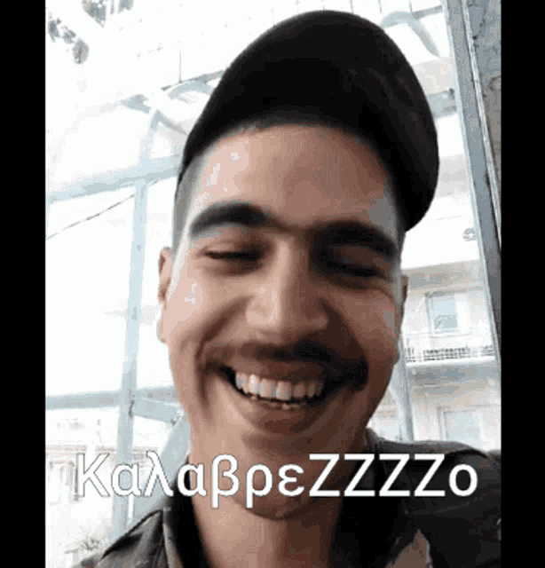 a man wearing a hat is smiling with the words kalabpezzzo on the bottom right