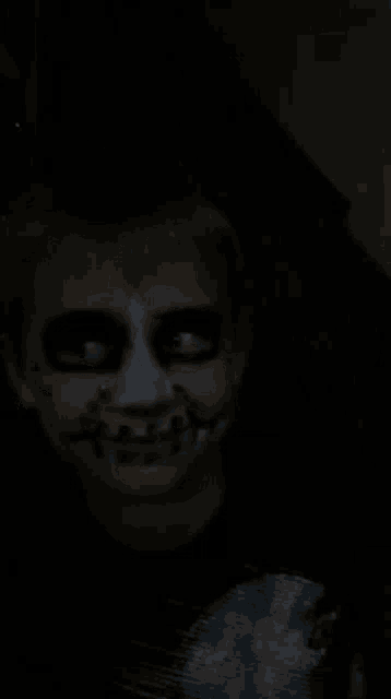 a boy with his face painted like a zombie