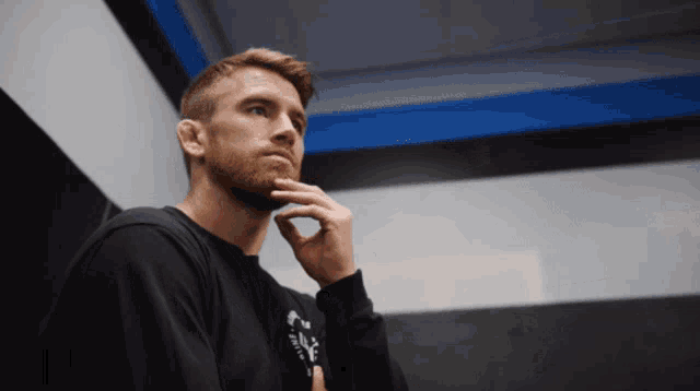 a man with a beard is wearing a black sweatshirt that says ' nc ' on it