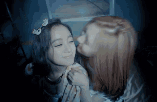 a woman kisses another woman on the cheek