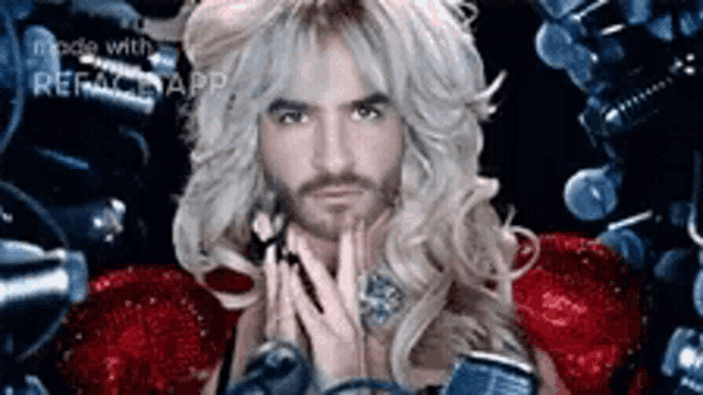 a man with blonde hair and a beard is holding a microphone