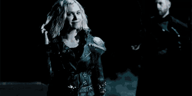 a woman is standing next to a man in a dark room .