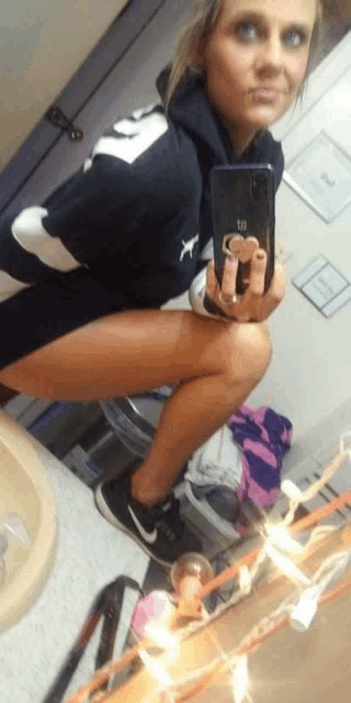 a woman is taking a picture of herself in a bathroom with her phone