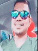 a man wearing sunglasses and a green shirt is taking a selfie .