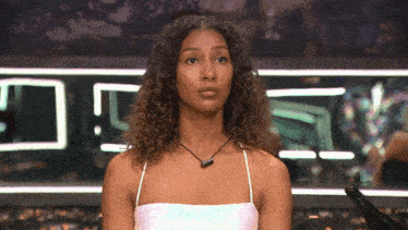 a woman with curly hair is standing in front of a sign that says ' nc '
