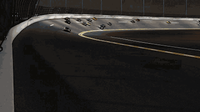 two racing cars are driving down a track at night