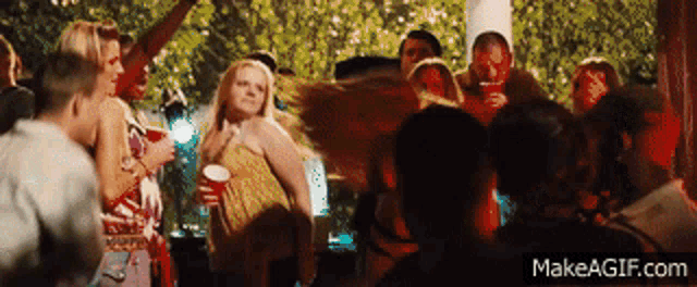 a group of people are dancing at a party on make a gif