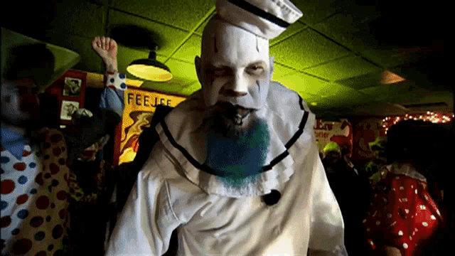 a clown is standing in front of a sign that says feel us