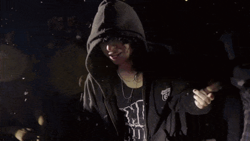 a person wearing a hoodie and a shirt that says ' i love you ' on it stands in a crowd