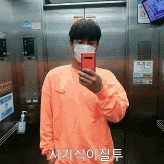 a man wearing a mask is taking a selfie in an elevator