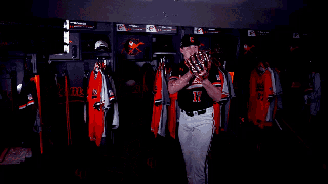 a baseball player laying on his back in a locker room with a jersey that says orioles on it