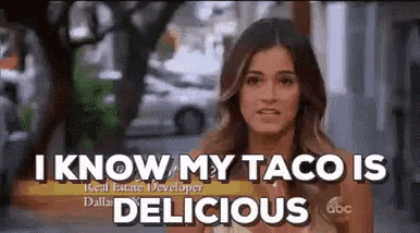 a woman is standing in front of a sign that says `` i know my taco is delicious `` .