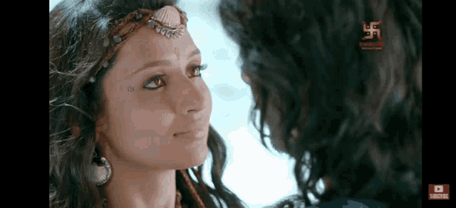 a man and a woman are looking at each other and the woman has a tattoo on her face