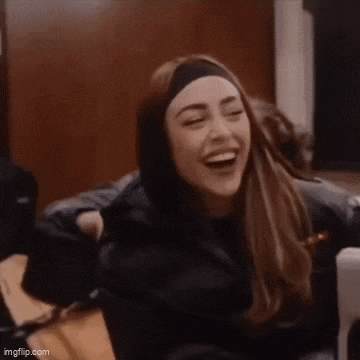 a woman wearing a headband is laughing while sitting on a chair .