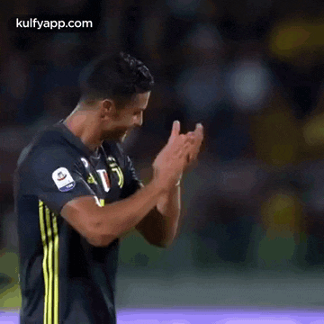 a soccer player is clapping his hands during a game .