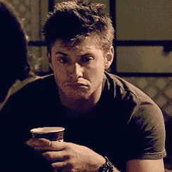 a man in a black shirt is holding a cup of coffee