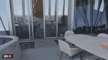 a sliding glass door is open to a room with a table and chairs and the words as tv on the bottom right