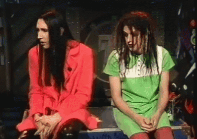 a man in a red jacket and a woman in a green shirt are sitting next to each other