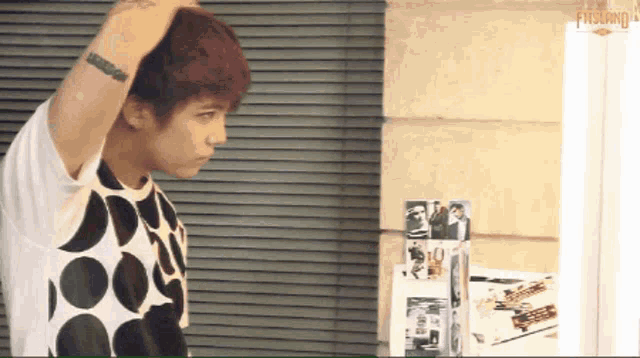 a man with a tattoo on his arm looks at himself in a mirror