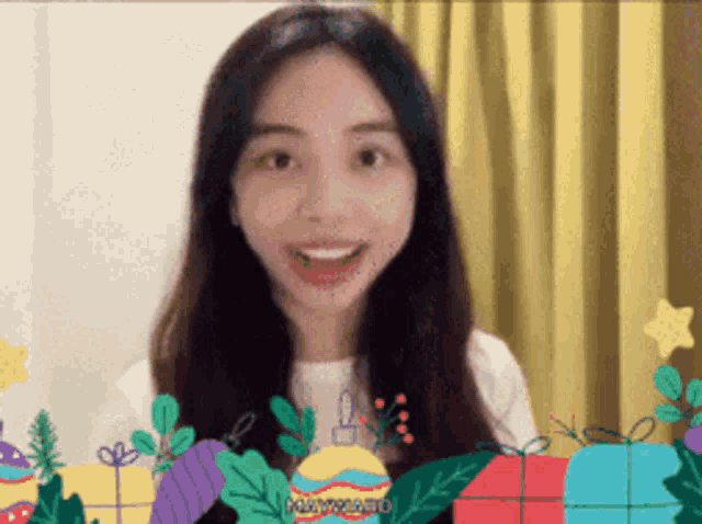 a woman is smiling in front of a yellow curtain surrounded by christmas presents and decorations including one that says maxplast