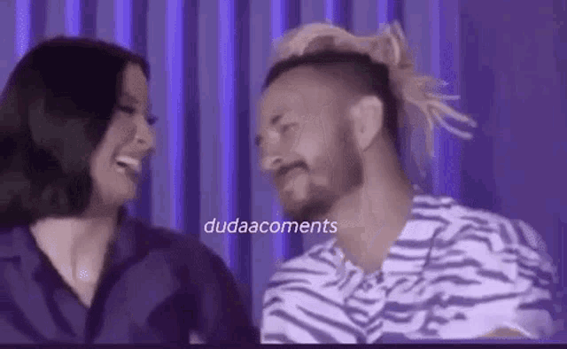 a man and a woman are laughing and looking at each other .