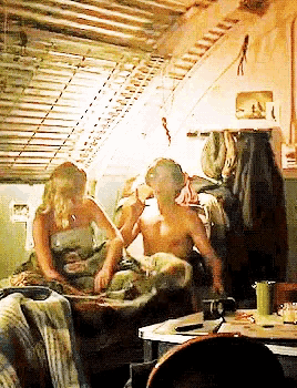 a man and a woman sit on a couch in a room