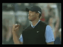 a man wearing a black hat and a nike vest is standing in front of a crowd