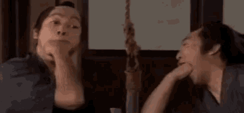 a man and a woman are sitting next to each other and talking to each other in a room .