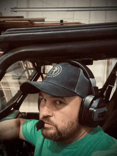a man wearing headphones and a hat with the letter r on it