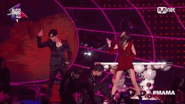 a woman in a red dress is dancing on a stage with a mnet logo