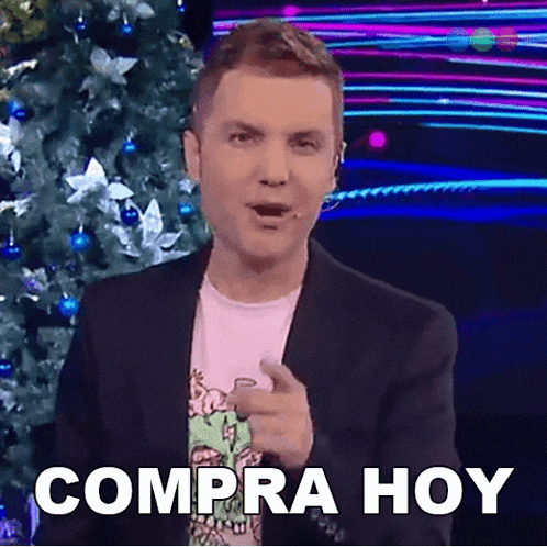 a man in front of a christmas tree is pointing at the camera with the words compra hoy behind him