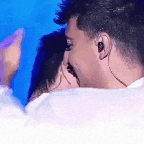 a man and a woman are kissing each other on a stage .