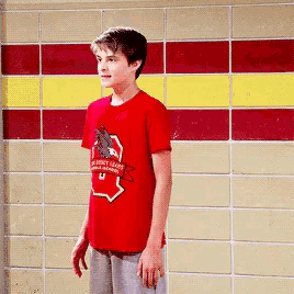 a boy wearing a red shirt that says ' mighty lion ' on it