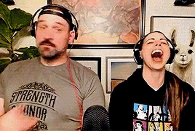 a man and a woman wearing headphones and a shirt that says strength honor are laughing .