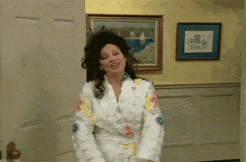 a woman in a bathrobe is dancing in a room with a picture on the wall .