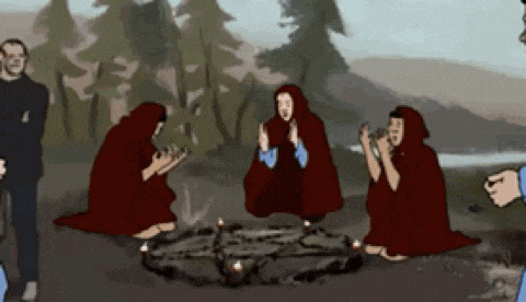 a group of people are sitting around a circle with candles in it .