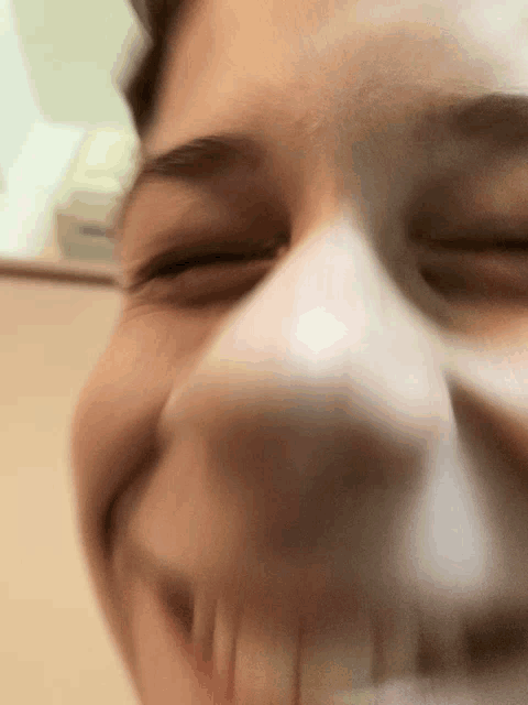 a close up of a person 's face with their eyes closed and a smile on their face