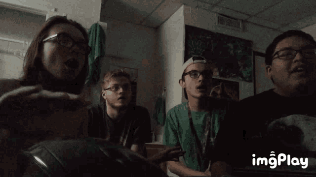 a group of people laughing in a room with a gif that says imgplay at the bottom