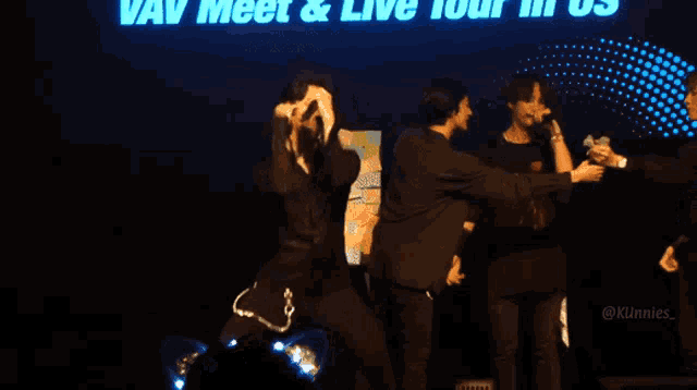 a group of people on a stage with the words " vav meet & live tour in us " behind them