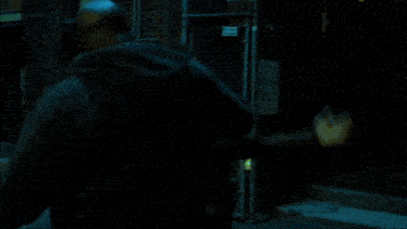 a man in a dark room with a boxing glove on