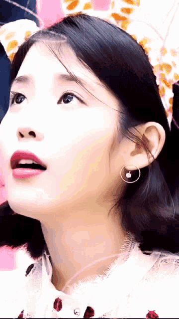 a close up of a woman wearing hoop earrings and a headband