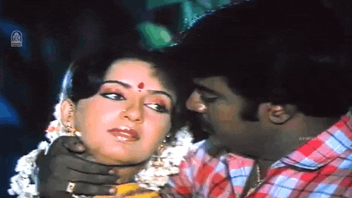 a man is kissing a woman on the forehead in a movie scene
