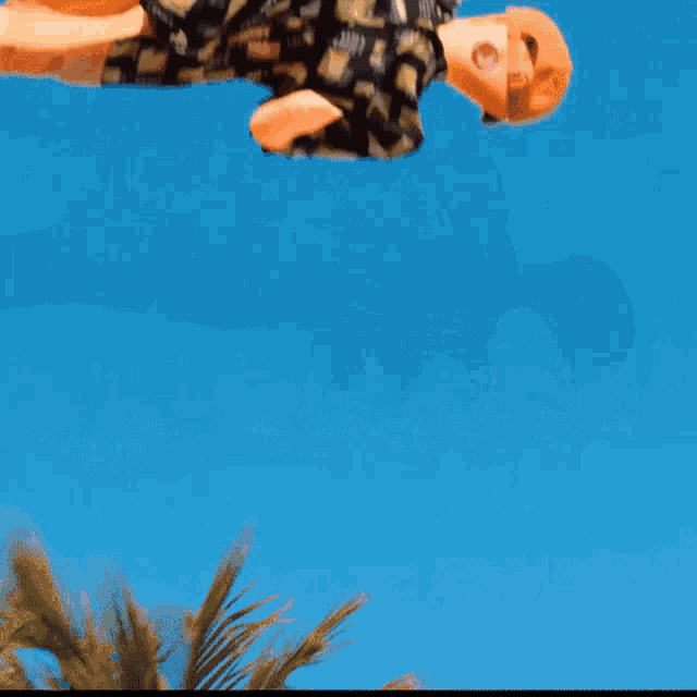 a doll is doing a handstand in the air against a blue sky