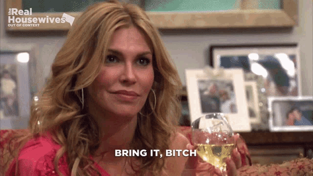 a woman holding a glass of wine with the words bring it bitch above her