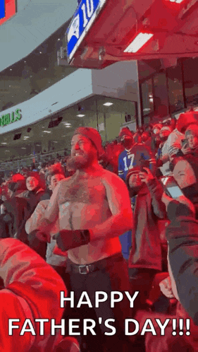 a man without a shirt is dancing in a crowd of people at a football game on father 's day .