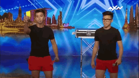 a couple of men standing on a stage with the word axn on the bottom