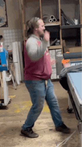 a man is dancing in a room in front of a pool table .