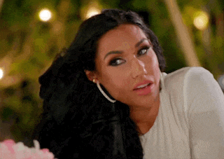 a woman with long black hair is sitting at a table with a cake .